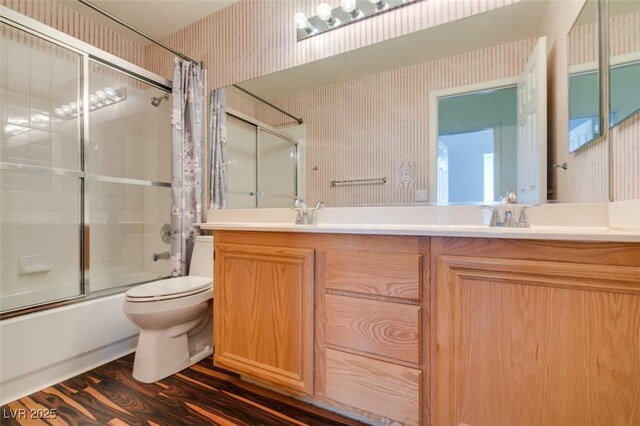 3336 Hidden Ridge St, Las Vegas, NV 89129 - full bathroom featuring wallpapered walls, bath / shower combo with glass door, double vanity, toilet, and wood finished floors