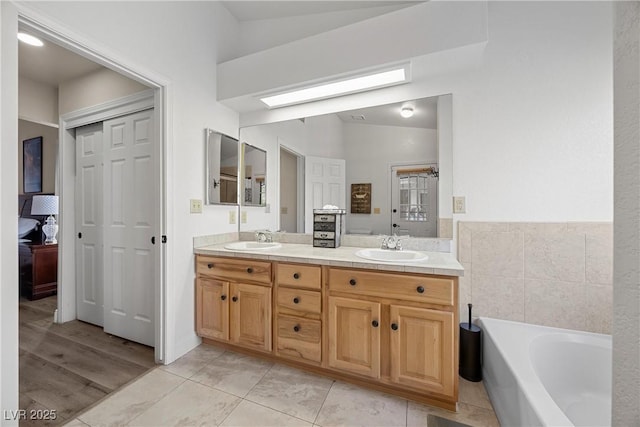 5020 Linkside Dr, Las Vegas, NV 89130 - ensuite bathroom with double vanity, a bath, and vaulted ceiling