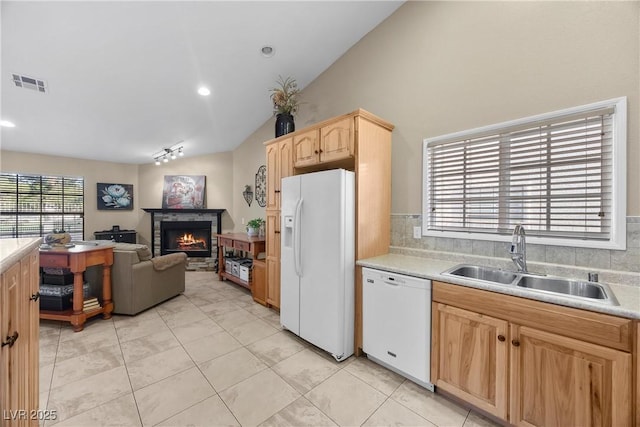 5020 Linkside Dr, Las Vegas, NV 89130 - kitchen featuring white appliances, a sink, vaulted ceiling, light brown cabinetry, and light countertops