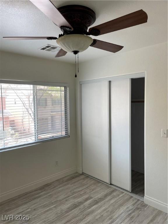 5280 Shreve Ave, Las Vegas, NV 89156 - unfurnished bedroom with light wood-style flooring, a closet, baseboards, and ceiling fan