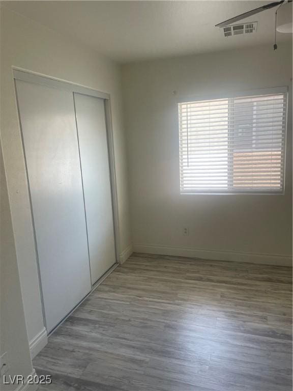 5280 Shreve Ave, Las Vegas, NV 89156 - unfurnished bedroom with wood finished floors, a closet, and baseboards