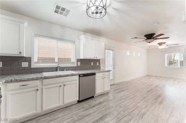 5280 Shreve Ave, Las Vegas, NV 89156 - kitchen with stainless steel dishwasher, white cabinetry, decorative backsplash, and open floor plan