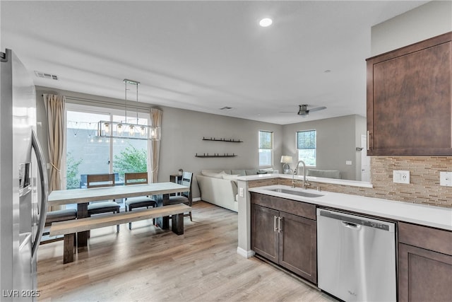 3132 Cartanda Ave, Henderson, NV 89044 - kitchen featuring a sink, stainless steel appliances, dark brown cabinets, backsplash, and light countertops