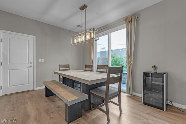 3132 Cartanda Ave, Henderson, NV 89044 - dining room featuring wine cooler, light wood-style flooring, baseboards, and a chandelier