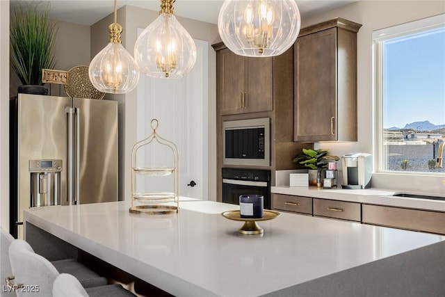 2151 Noble Perch St, Las Vegas, NV 89138 - kitchen featuring stainless steel appliances, a chandelier, light countertops, pendant lighting, and plenty of natural light