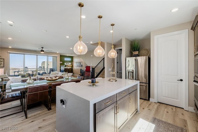 2151 Noble Perch St, Las Vegas, NV 89138 - kitchen featuring stainless steel fridge with ice dispenser, light wood-style flooring, ceiling fan, open floor plan, and a center island