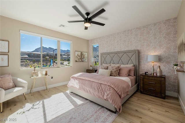 2151 Noble Perch St, Las Vegas, NV 89138 - bedroom with wallpapered walls, light wood-style flooring, a mountain view, and ceiling fan