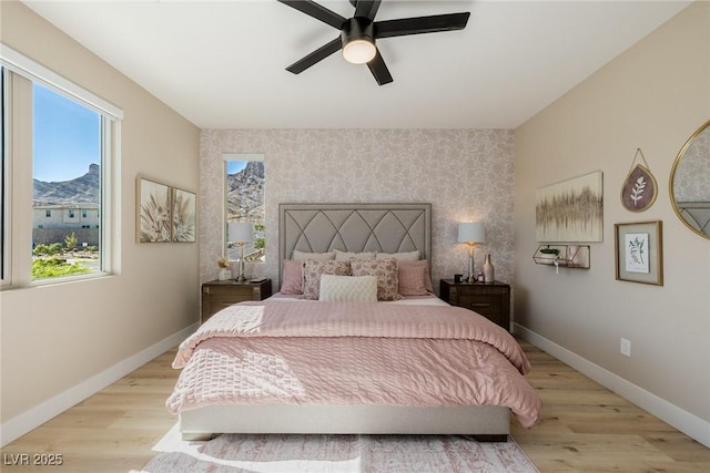 2151 Noble Perch St, Las Vegas, NV 89138 - bedroom featuring an accent wall, multiple windows, wood finished floors, and wallpapered walls