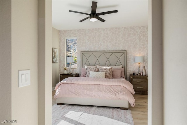 2151 Noble Perch St, Las Vegas, NV 89138 - bedroom featuring wallpapered walls, an accent wall, wood finished floors, and a ceiling fan