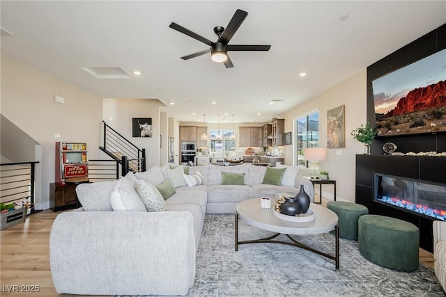 2151 Noble Perch St, Las Vegas, NV 89138 - living room with light wood finished floors, a ceiling fan, stairway, a glass covered fireplace, and recessed lighting
