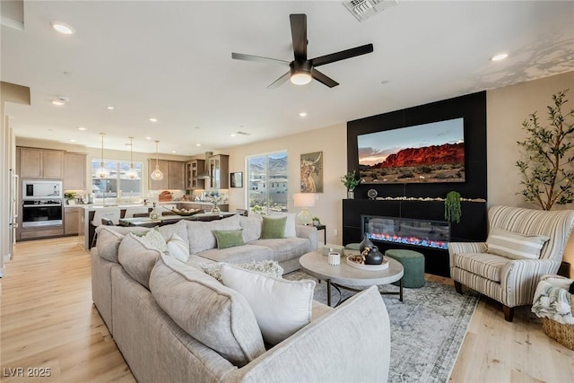 2151 Noble Perch St, Las Vegas, NV 89138 - living area featuring ceiling fan, light wood-type flooring, recessed lighting, and a glass covered fireplace