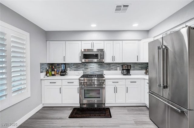 8316 Maplestar Rd, Las Vegas, NV 89128 - kitchen with high end appliances, tasteful backsplash, light countertops, baseboards, and white cabinets