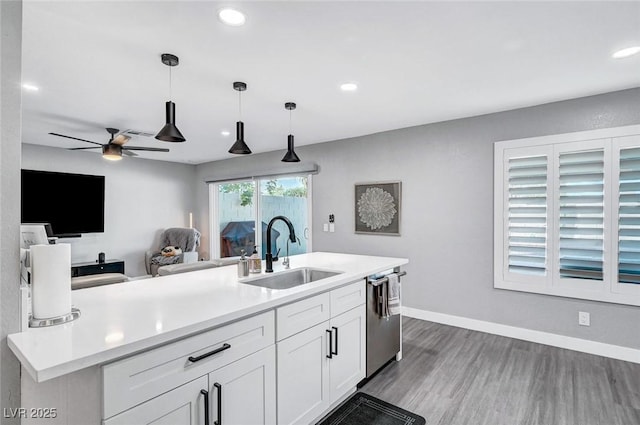 8316 Maplestar Rd, Las Vegas, NV 89128 - kitchen with a sink, dishwasher, wood finished floors, decorative light fixtures, and light countertops