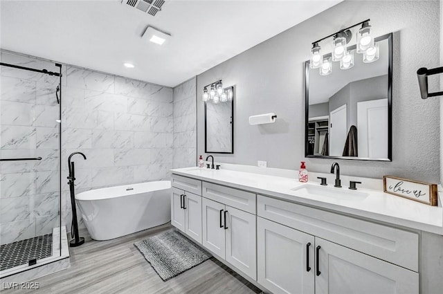 8316 Maplestar Rd, Las Vegas, NV 89128 - bathroom with double vanity, a freestanding tub, a shower stall, and wood finished floors
