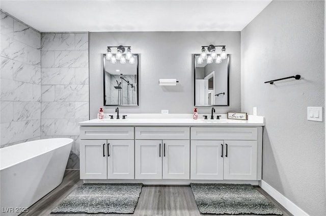 8316 Maplestar Rd, Las Vegas, NV 89128 - bathroom featuring double vanity, a soaking tub, wood finished floors, and baseboards