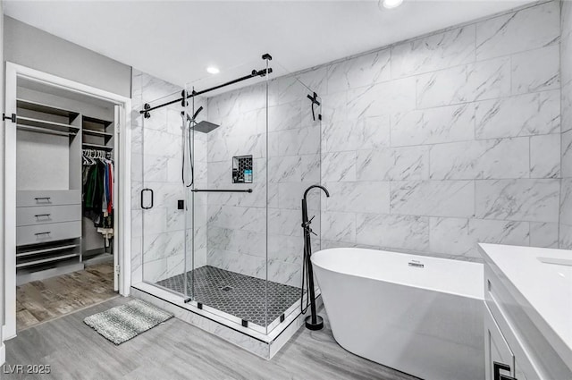 8316 Maplestar Rd, Las Vegas, NV 89128 - full bathroom featuring a freestanding tub, a shower stall, recessed lighting, wood finished floors, and a walk in closet