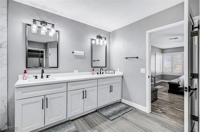 8316 Maplestar Rd, Las Vegas, NV 89128 - ensuite bathroom featuring wood finished floors, double vanity, and baseboards