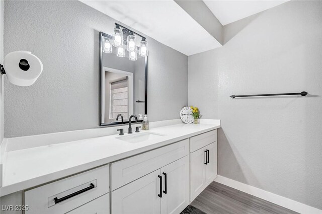 8316 Maplestar Rd, Las Vegas, NV 89128 - bathroom featuring vanity, wood finished floors, baseboards, and a textured wall