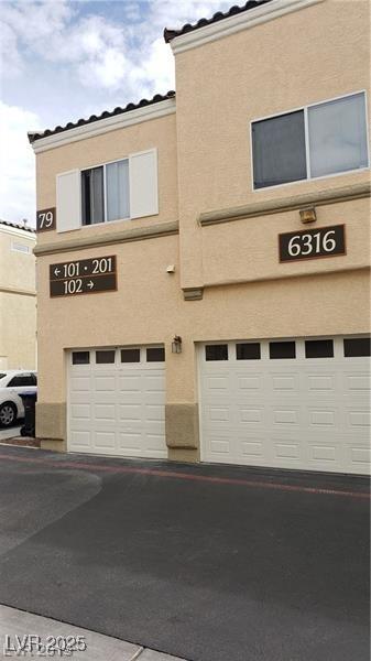 6316 Beige Bluff St Unit 201, North Las Vegas, NV 89081 - view of property with an attached garage and driveway