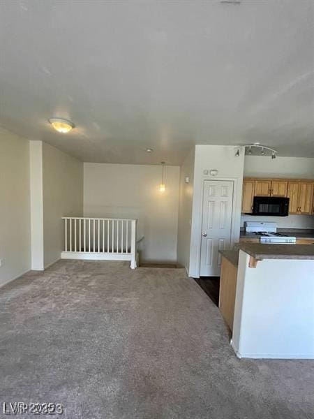 6316 Beige Bluff St Unit 201, North Las Vegas, NV 89081 - kitchen with black microwave, dark countertops, gas range oven, carpet floors, and open floor plan