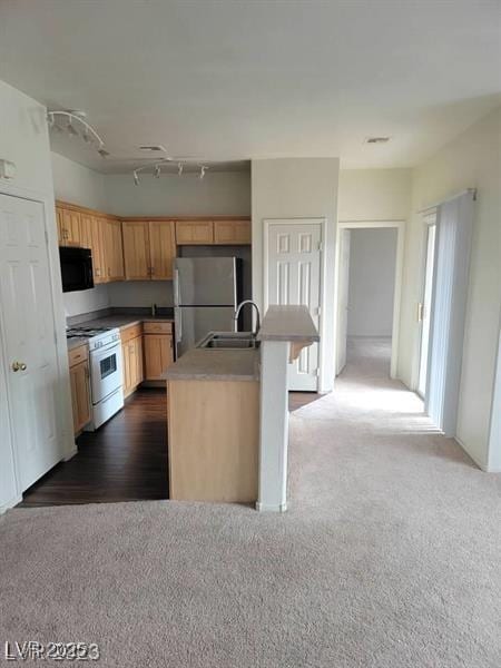 6316 Beige Bluff St Unit 201, North Las Vegas, NV 89081 - kitchen featuring white range with gas cooktop, freestanding refrigerator, a sink, dark carpet, and a kitchen island with sink
