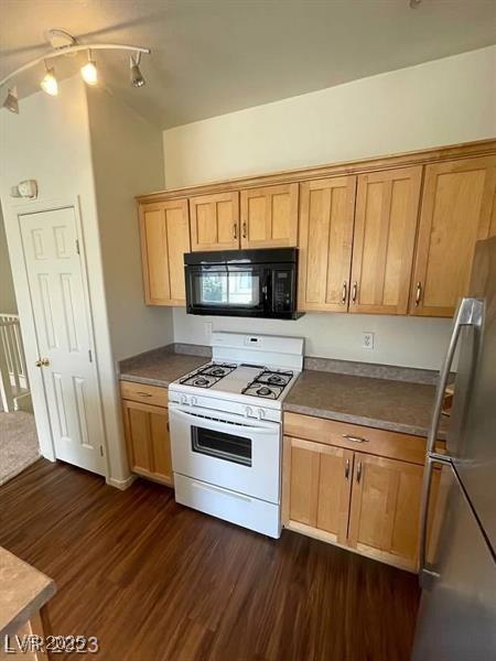 6316 Beige Bluff St Unit 201, North Las Vegas, NV 89081 - kitchen with black microwave, white range with gas stovetop, freestanding refrigerator, dark wood-style flooring, and dark countertops