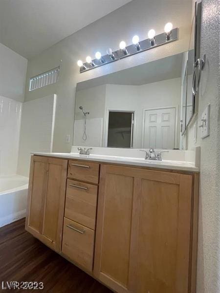 6316 Beige Bluff St Unit 201, North Las Vegas, NV 89081 - bathroom featuring wood finished floors, double vanity, shower / bath combination, and a textured wall