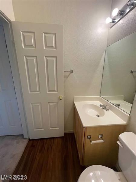 6316 Beige Bluff St Unit 201, North Las Vegas, NV 89081 - half bathroom featuring vanity, toilet, and wood finished floors