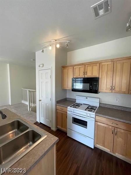 6316 Beige Bluff St Unit 201, North Las Vegas, NV 89081 - kitchen with black microwave, white gas range oven, a sink, dark wood-style flooring, and dark countertops