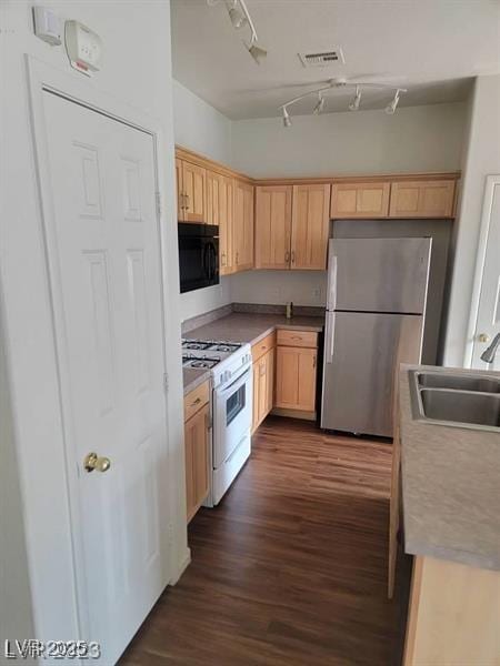 6316 Beige Bluff St Unit 201, North Las Vegas, NV 89081 - kitchen featuring freestanding refrigerator, gas range gas stove, black microwave, a sink, and light brown cabinets
