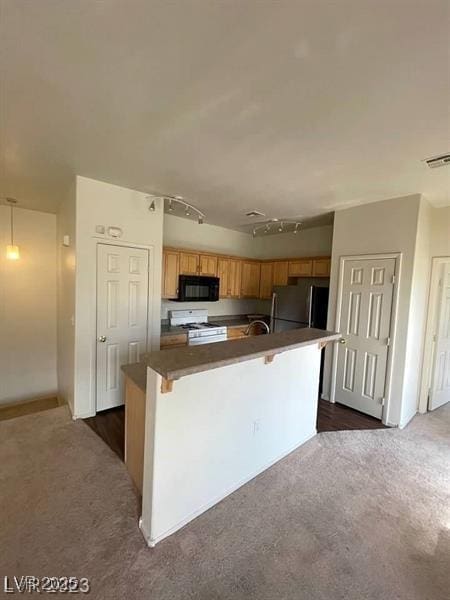 6316 Beige Bluff St Unit 201, North Las Vegas, NV 89081 - kitchen featuring black microwave, freestanding refrigerator, white gas range, dark countertops, and dark colored carpet