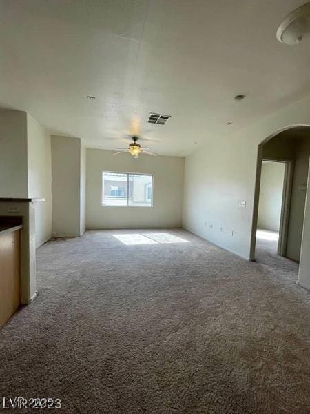 6316 Beige Bluff St Unit 201, North Las Vegas, NV 89081 - unfurnished living room featuring arched walkways, carpet, and a ceiling fan
