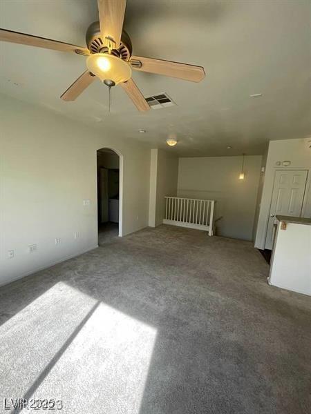 6316 Beige Bluff St Unit 201, North Las Vegas, NV 89081 - unfurnished living room with arched walkways, carpet, and a ceiling fan