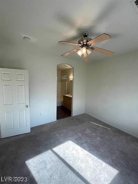 6316 Beige Bluff St Unit 201, North Las Vegas, NV 89081 - unfurnished bedroom with arched walkways, dark colored carpet, ceiling fan, and connected bathroom