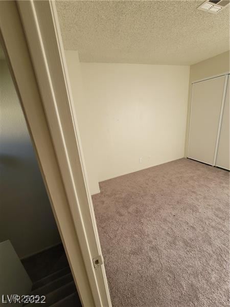 4363 Spencer St Unit 8, Las Vegas, NV 89119 - unfurnished bedroom featuring a textured ceiling and carpet floors