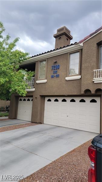 7290 Sheared Cliff Ln Unit 102, Las Vegas, NV 89149 - view of side of property featuring a garage, a balcony, and concrete driveway