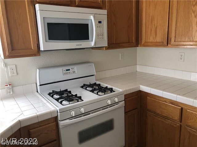 75 N Valle Verde Dr Unit 2121, Henderson, NV 89074 - kitchen featuring white appliances, brown cabinetry, and light countertops