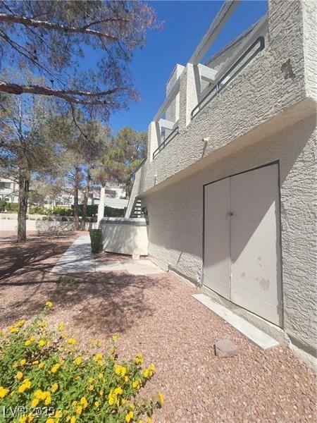 2761 Lodestone Dr Unit 63, Las Vegas, NV 89117 - view of property exterior featuring stucco siding, stairs, and a patio