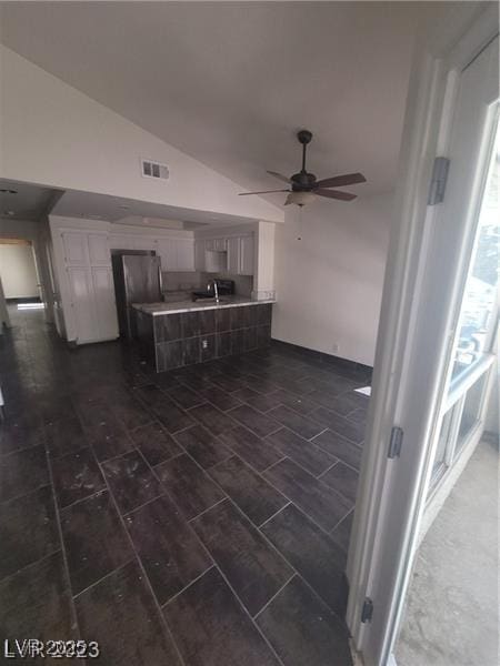 2761 Lodestone Dr Unit 63, Las Vegas, NV 89117 - kitchen with a peninsula, lofted ceiling, ceiling fan, light countertops, and white cabinets