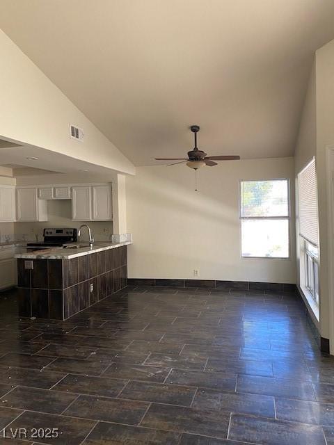 2761 Lodestone Dr Unit 63, Las Vegas, NV 89117 - unfurnished living room featuring vaulted ceiling, a ceiling fan, a sink, and baseboards