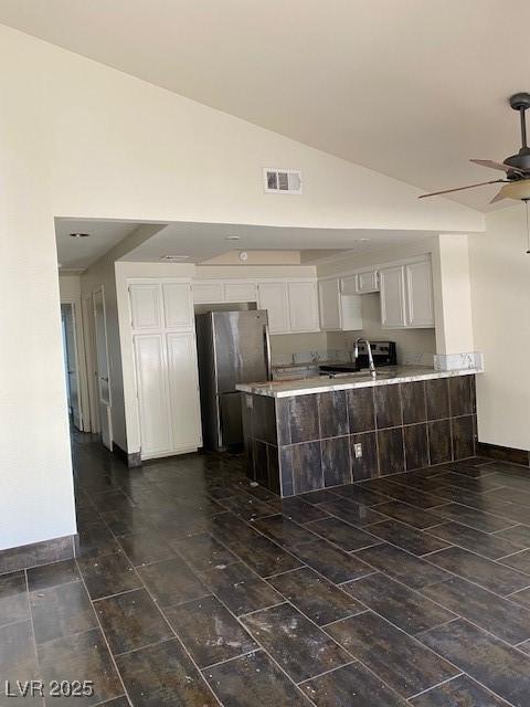 2761 Lodestone Dr Unit 63, Las Vegas, NV 89117 - kitchen with freestanding refrigerator, a ceiling fan, light countertops, a sink, and white cabinets