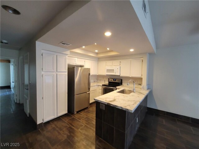 2761 Lodestone Dr Unit 63, Las Vegas, NV 89117 - kitchen with appliances with stainless steel finishes, a sink, a peninsula, white cabinets, and baseboards