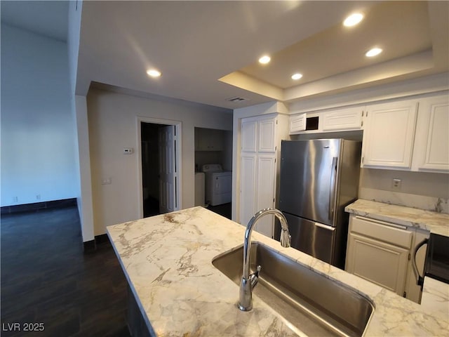 2761 Lodestone Dr Unit 63, Las Vegas, NV 89117 - kitchen featuring freestanding refrigerator, a sink, washer and clothes dryer, white cabinets, and recessed lighting