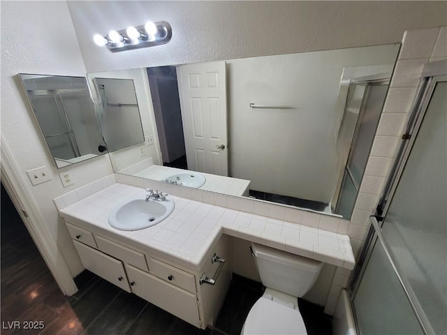 2761 Lodestone Dr Unit 63, Las Vegas, NV 89117 - full bathroom with a shower with shower door, vanity, toilet, wood finished floors, and baseboards