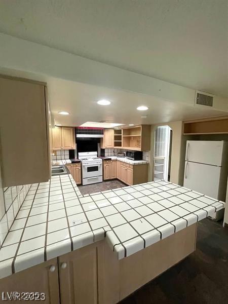 3797 Monument St, Las Vegas, NV 89121 - kitchen with tile countertops, white appliances, open shelves, recessed lighting, and a peninsula