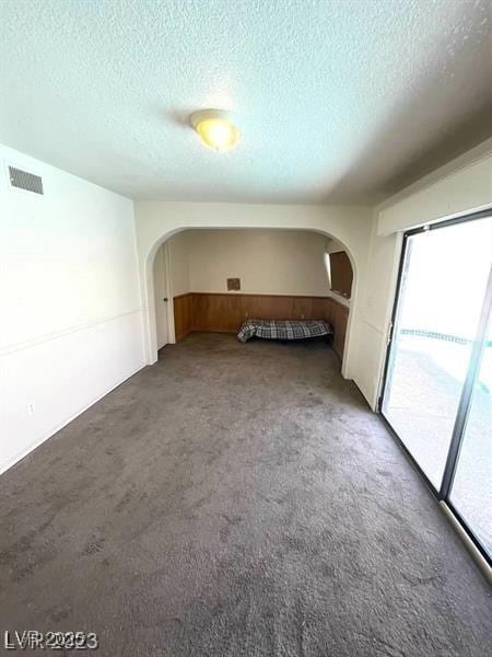 3797 Monument St, Las Vegas, NV 89121 - carpeted empty room with arched walkways and a textured ceiling