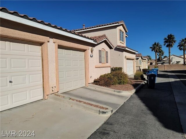 70 Belle Essence Ave, Las Vegas, NV 89123 - view of home's exterior with stucco siding, a tiled roof, and driveway