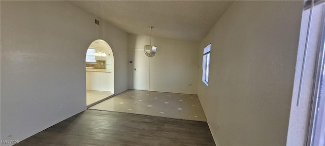 1301 Madison Ave, Las Vegas, NV 89106 - unfurnished dining area featuring lofted ceiling, wood finished floors, and arched walkways