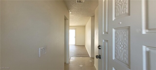 1301 Madison Ave, Las Vegas, NV 89106 - corridor with a textured ceiling, light tile patterned floors, and baseboards