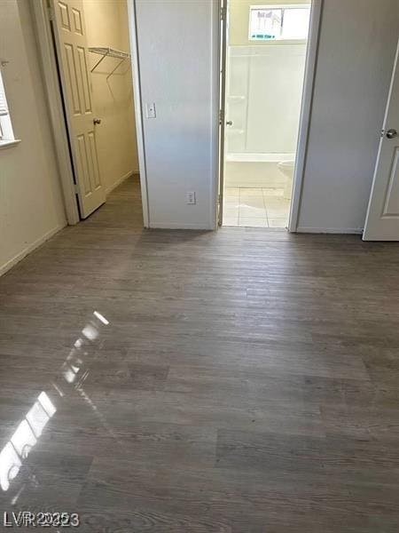 5284 Wellesley Ave, Las Vegas, NV 89122 - unfurnished bedroom featuring wood finished floors, baseboards, connected bathroom, a walk in closet, and a closet